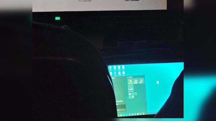 Viral pic shows Bengaluru man working on laptop while watching a film in theatre